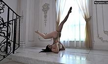 Dasha Gaga, eine tätowierte Teenagerin mit atemberaubendem Körperbau, führt akrobatische Bewegungen auf dem Boden aus
