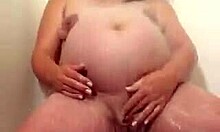 Mama însărcinată uriașă se masturbează seducător sub duș