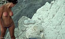 Беба у тангама показује своје дупе на нудистичкој плажи
