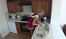Kırmızı kalkan sarışın kız arkadaş bulaşıkları yıkıyor, sıcak görünüyor