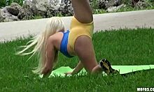 Блондинка-йога-девушка тренируется в общественном парке