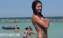 Prsnatá brunetka s úžasným telom predvádza svoje opálenie na pláži