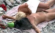 Blondie runker kjærestens kuk på en strand