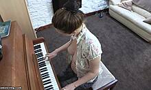 Игривая брюнетка с упругой грудью играет на пианино топлес