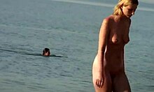 Blondă cu sânii mari face lucruri pe o plajă de nudiști, arătând fierbinte