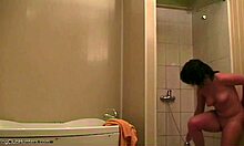 Piękna kobieta relaksuje się pod prysznicem i jest obserwowana