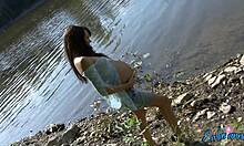 Seorang wanita hamil memamerkan tubuhnya yang setengah telanjang di dekat air